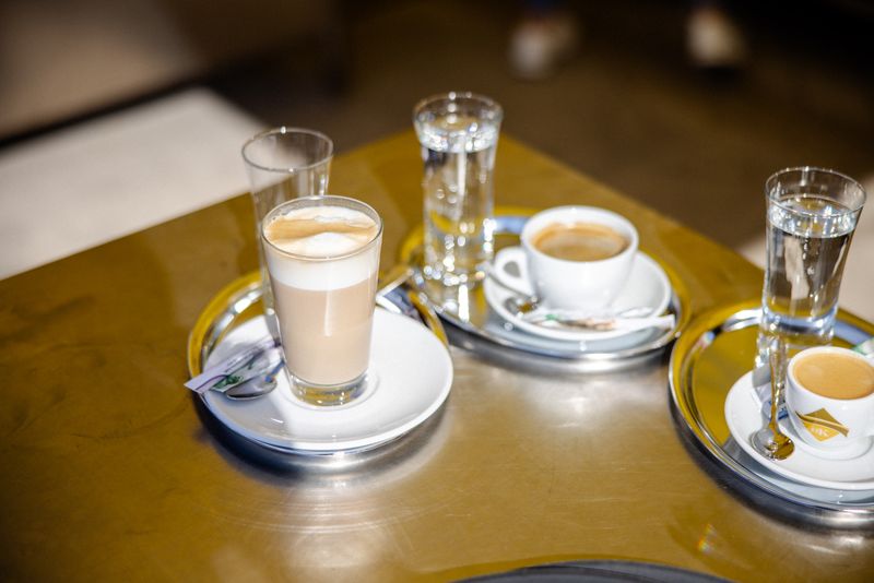 Melange, Espresso und Wassergläser auf einem Tablett