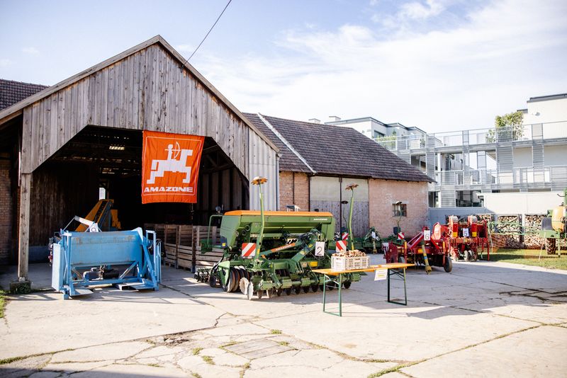 Hof mit Holzscheune und landwirtschaftlichen Maschinen