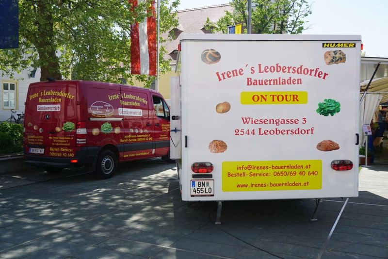 Roter Lieferwagen und Verkaufsanhänger mit der Aufschrift „Irene´s Leobersdorfer Bauernladen – On Tour“